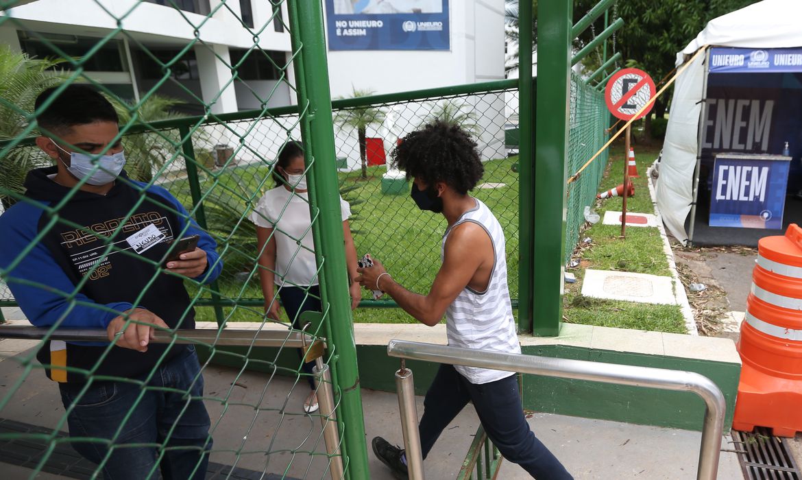 estudante entrando em escola para realizar a prova do enem