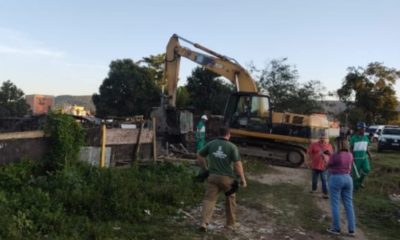 escavadeira demolindo construções irregulares em Guaratiba