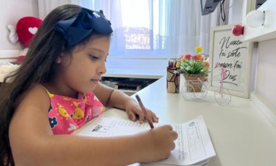 Nicolle de Paula Peixoto, de 8 anos, fazendo dever de casa