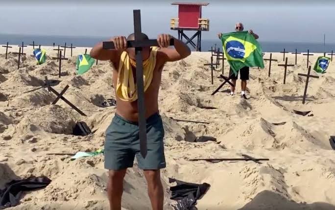 Homem colocando cruz na praia de Copacabana
