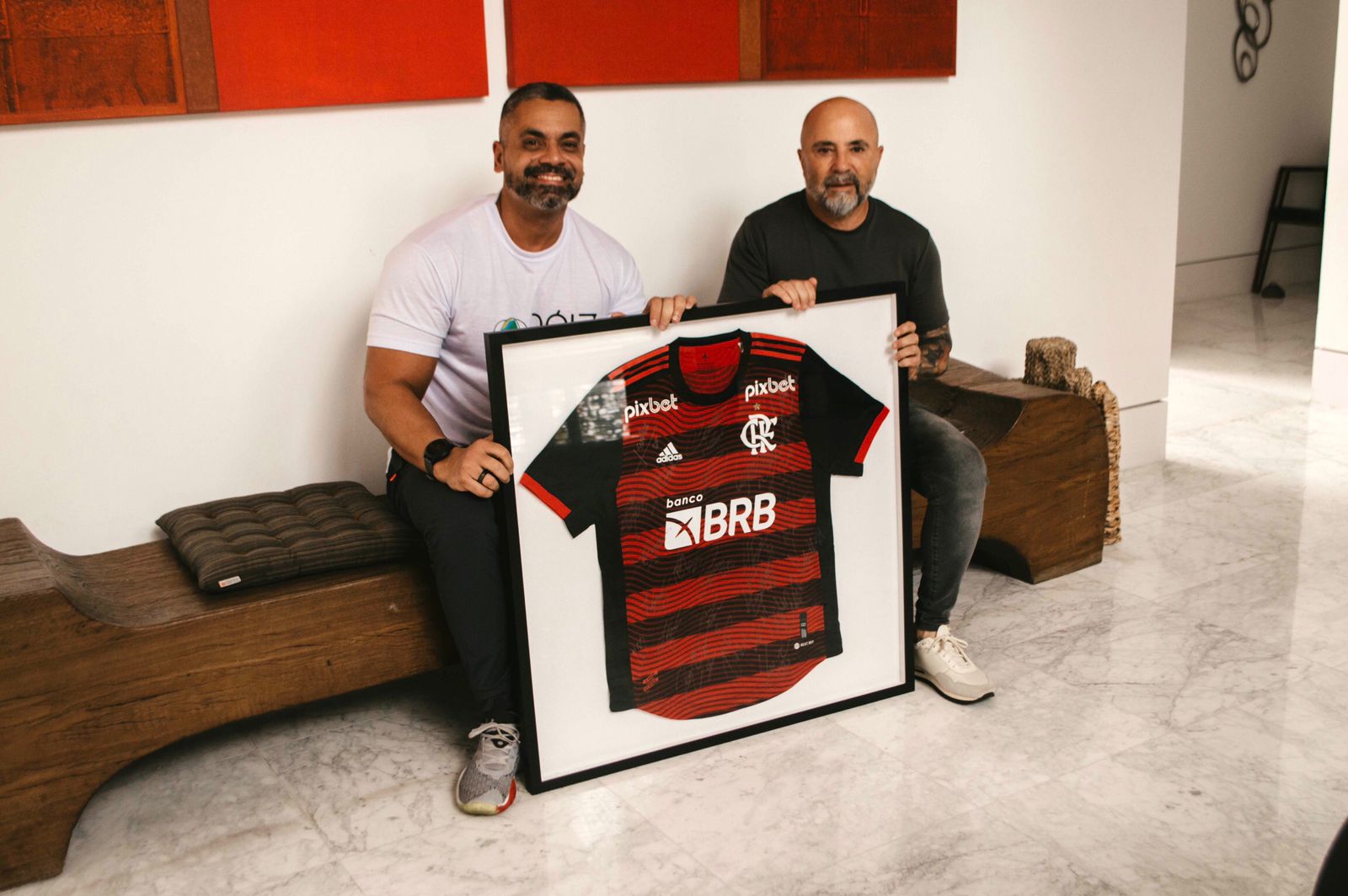 Sampaoli doa camisa do Flamengo autografada pelos jogadores para projeto social na Cidade de Deus (Foto: Divulgação)