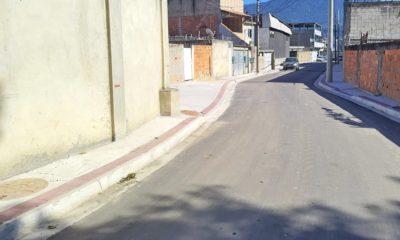Rua em Vila Kennedy pavimentada, com calçada reconstruída e escoamento de água de chuva.
