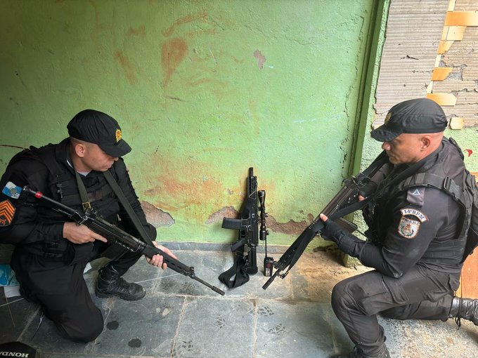 Policiais militares com fuzil apreendido na comunidade do Rebu