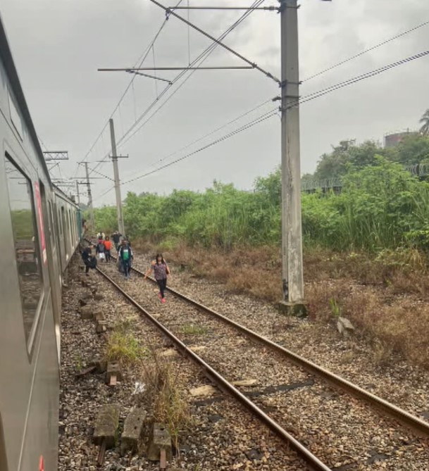 Passageiros caminham por trilhos após problemas nos trens a Supervia