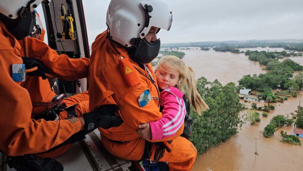 Bombeiros do Rio resgatam crianças das fortes chuvas no Rio Grande do Sul. 