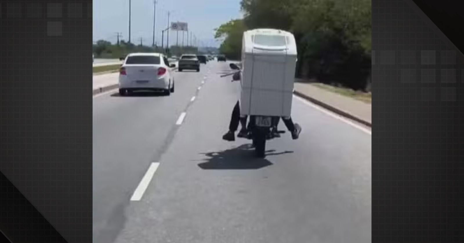 Motociclista carregando máquina de lavar na garupa em Guaratiba