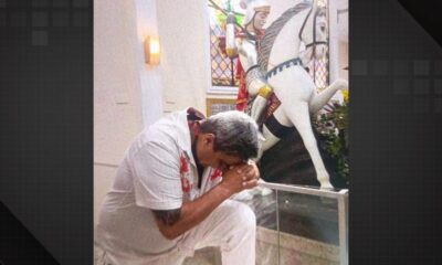 Homem ajoelhado em oração diante da imagem de São Jorge em igreja