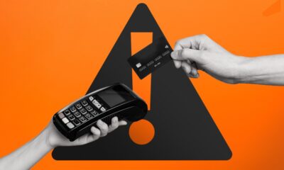 Duas mãos seguram máquina de cartão e um cartão preto. Fundo laranja com aviso.