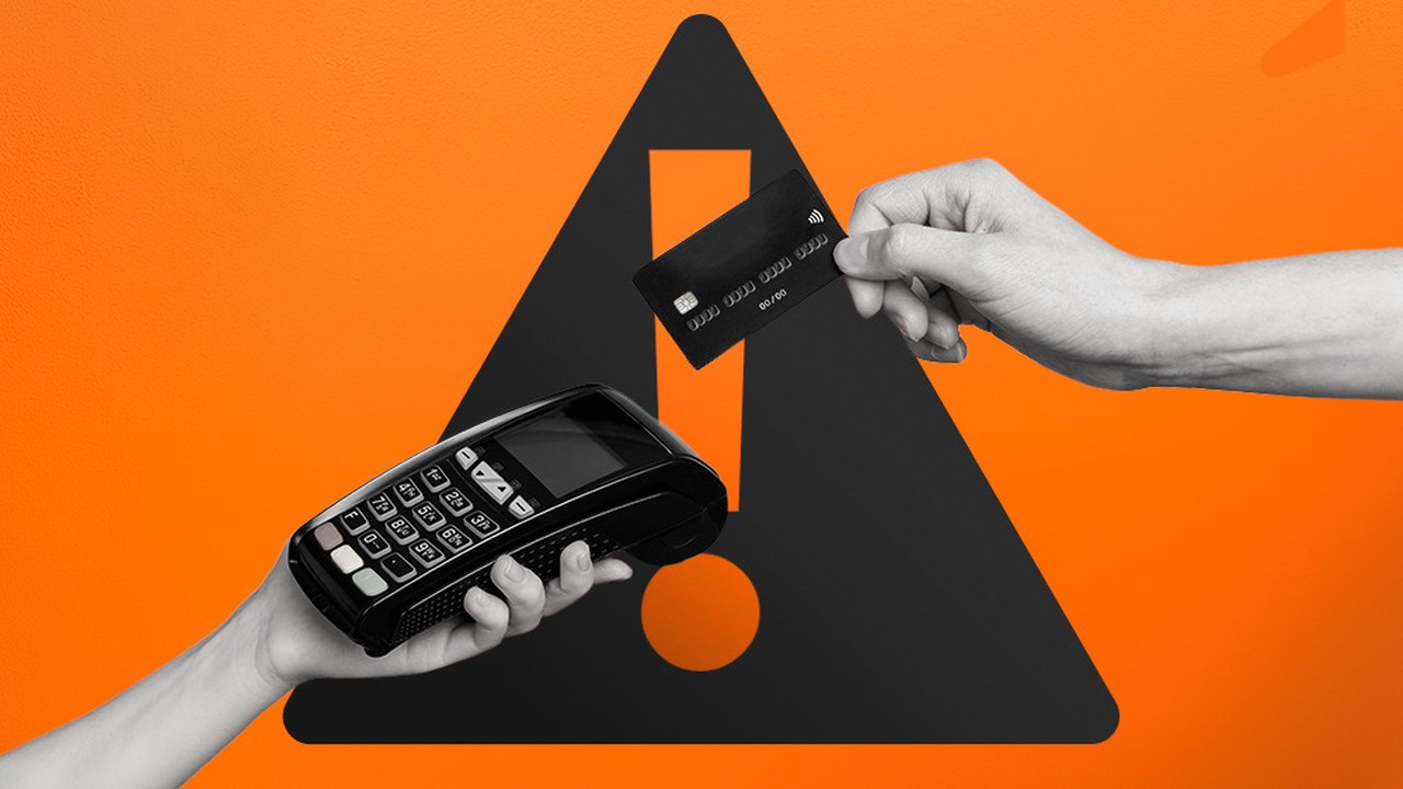 Duas mãos seguram máquina de cartão e um cartão preto. Fundo laranja com aviso.