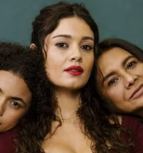 Atrizes Sophie Charlotte, Dira Paes e Alana Cabral, com cabelos escuros, sorrindo contra fundo verde.