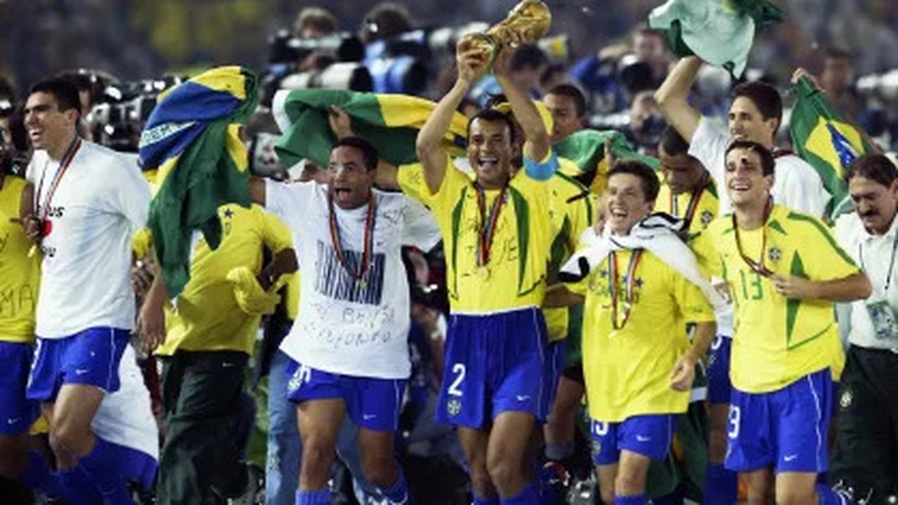 Jogadores brasileiros, com camisas amarelas, celebram vitória na Copa do Mundo com o troféu.