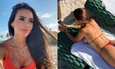 Bruna Biancardi sorrindo e deitada na praia de biquíni, usando celular.