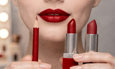 Close no batom vermelho de Taylor Swift, referência de maquiagem com tom clássico e fundo frio inspirado em Ruby Woo e Dragon Girl.