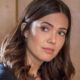 Mandy Moore, rosto e ombro, olhar pensativo para cima e para o lado.