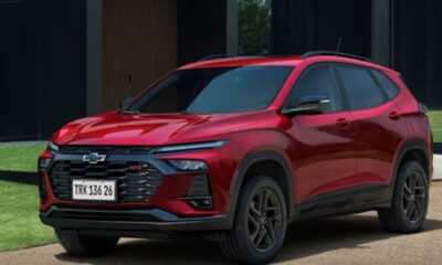 SUV Chevrolet Tracker RS vermelho, placa 'TRK 136 26', estacionado em frente a uma casa.