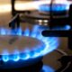 Chamas azuis brilhantes de um queimador de fogão a gás aceso com grades de ferro.