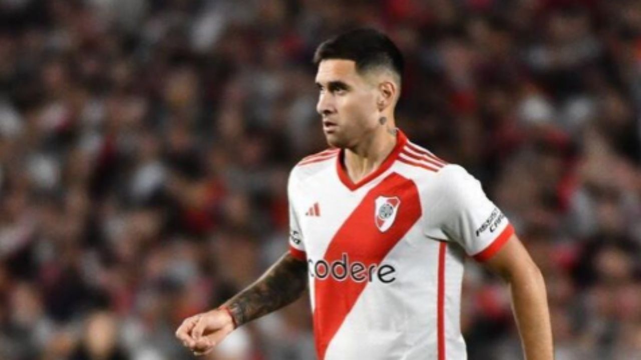 Jogador de futebol, camisa River Plate branca e vermelha, em campo.