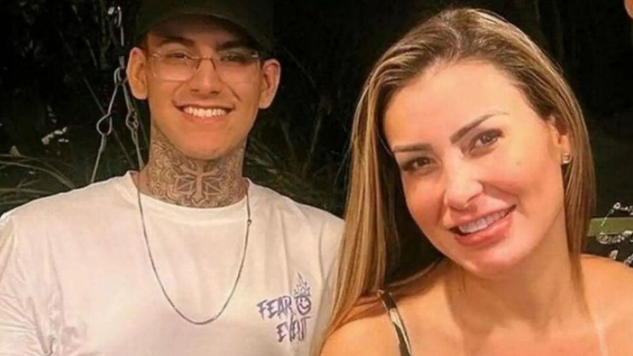 Andressa Urach e Arthur Urach sorrindo para a câmera, ele de óculos e tatuagens no pescoço.