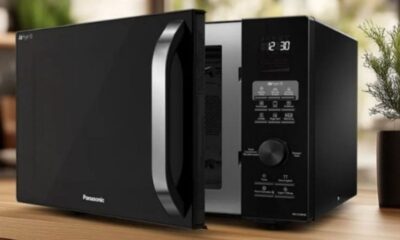 Forno micro-ondas Panasonic preto, porta entreaberta, display 12:30, função Airfry visível.