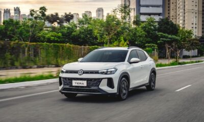 Volkswagen Tera branco SUV em movimento na estrada, com prédios e vegetação urbana ao fundo.