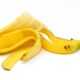 Casca de banana amarela parcialmente aberta e enrolada sobre um fundo branco.