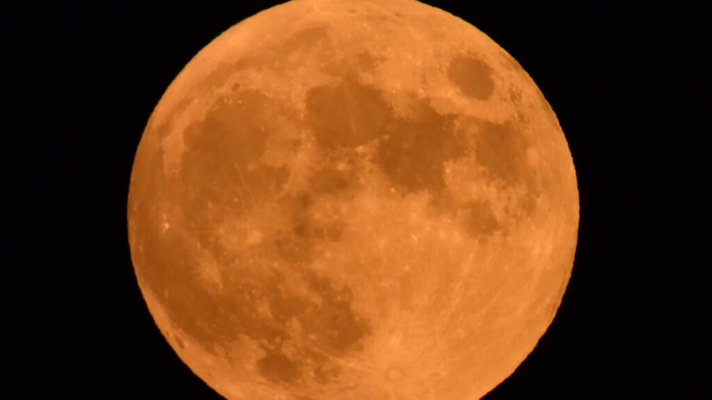 Perto do horizonte, a lua muda de cor e chama muita atenção