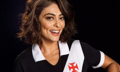 Juliana Paes sorrindo, vestindo camisa preta do Vasco com faixa branca e cruz vermelha.