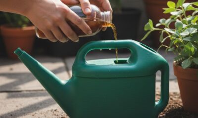 Mãos despejando líquido marrom de uma garrafa em um regador verde perto de plantas.