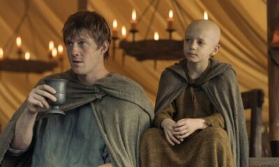 Ser Duncan o Alto, com copo, e Egg, o escudeiro careca, vestidos com mantos medievais.