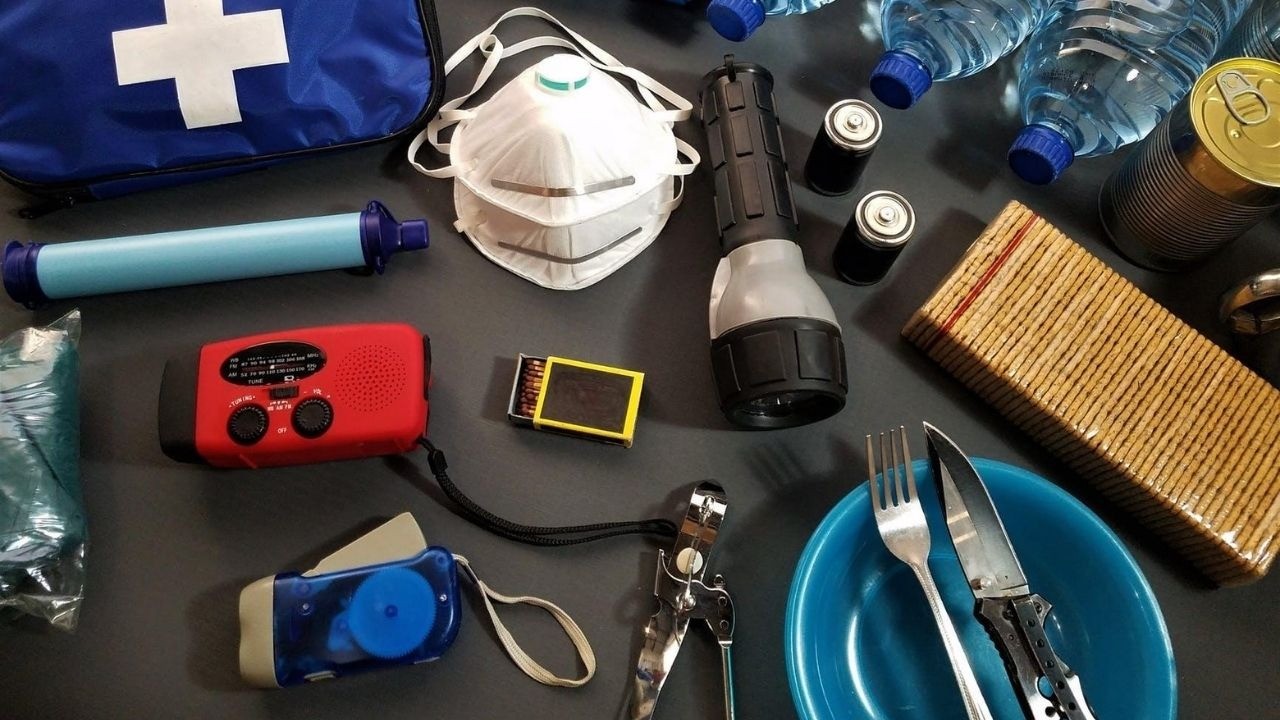 Kit de emergência com kit de primeiros socorros, máscaras, água, alimentos, rádio, lanternas e pilhas.