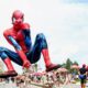 Gigante boneco do Homem-Aranha flutua sobre rua cheia de foliões em festa no Rio.