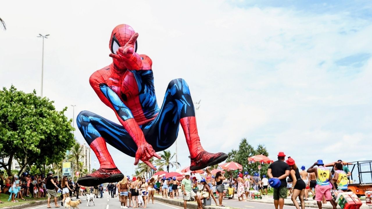 Gigante boneco do Homem-Aranha flutua sobre rua cheia de foliões em festa no Rio.