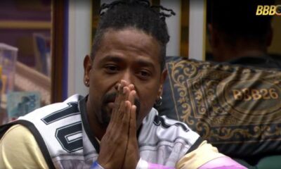 Homem de dreads com as mãos juntas, vestindo camisa de basquete número 10.