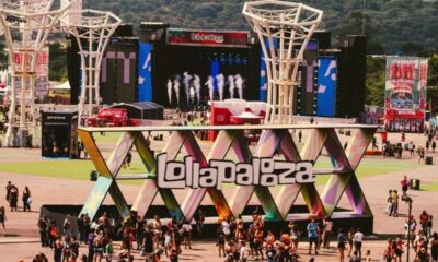 Festival Lollapalooza com grande sinal colorido "Lollapalooza", palco, torres, multidão e tendas.