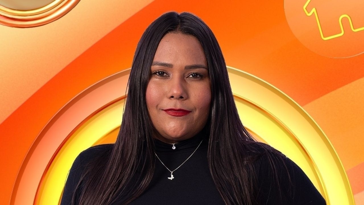 Retrato de Chaiany, mulher de cabelos escuros, blusa preta, colares e batom vermelho em fundo laranja.