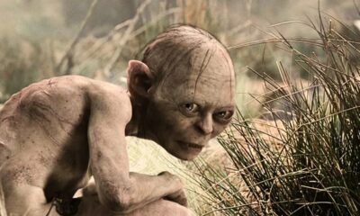 Close-up de Gollum agachado na grama, olhando intensamente para frente.