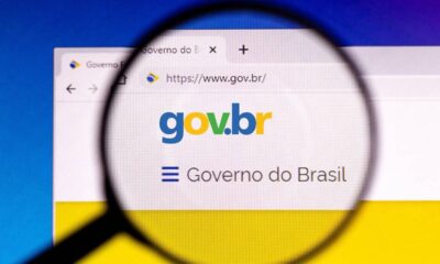Lupa sobre tela de computador exibindo o site gov.br e o texto 'Governo do Brasil'.