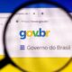 Lupa sobre tela de computador exibindo o site gov.br e o texto 'Governo do Brasil'.