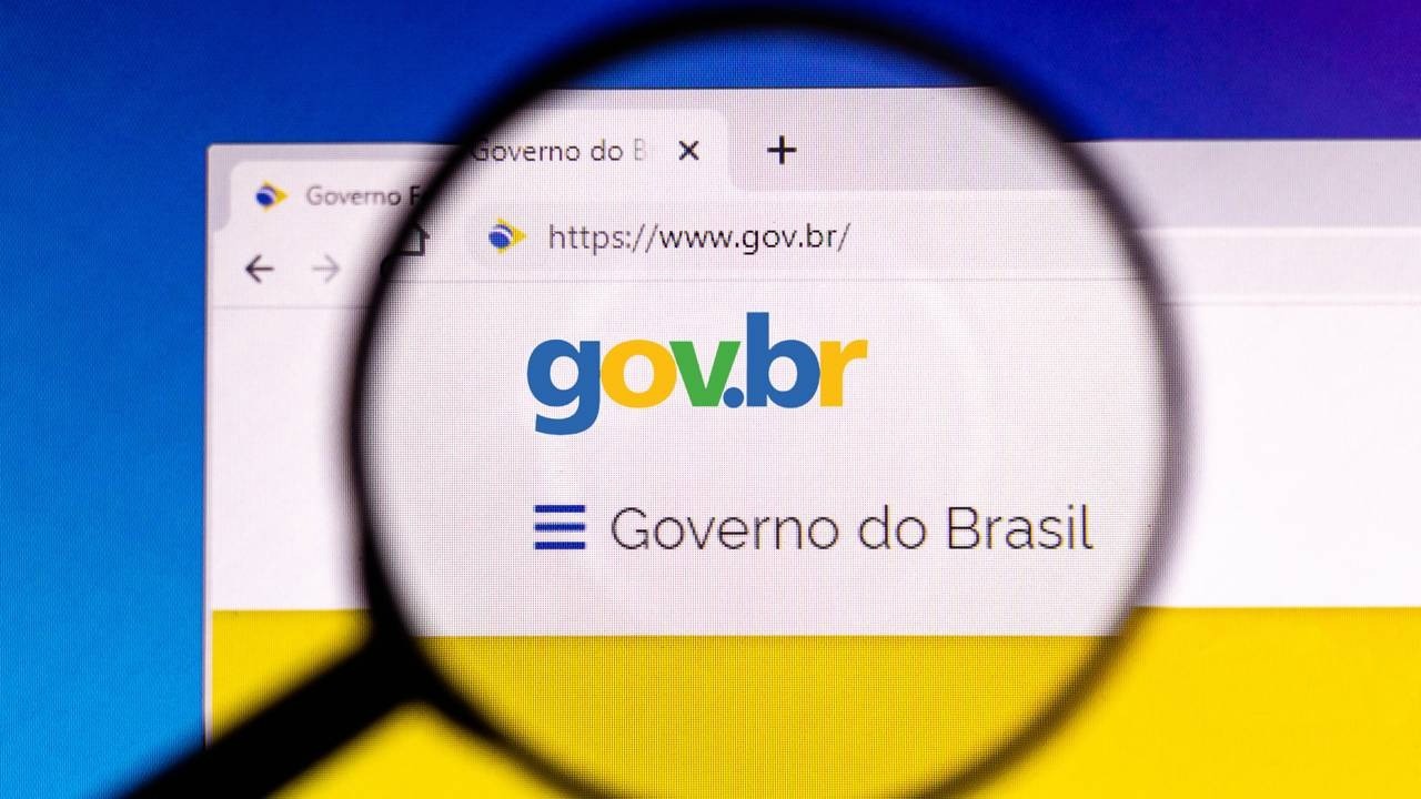 Lupa sobre tela de computador exibindo o site gov.br e o texto 'Governo do Brasil'.