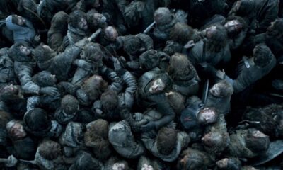 Visão aérea de muitos soldados amontoados e sujos em um campo de batalha lamacento.