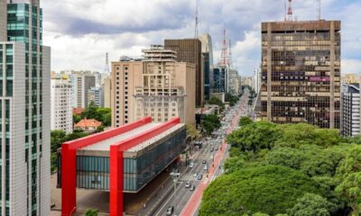 Vista aérea do MASP, Avenida Paulista, prédios e árvores em São Paulo sob céu nublado.