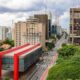 Vista aérea do MASP, Avenida Paulista, prédios e árvores em São Paulo sob céu nublado.