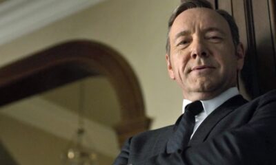 Rosto de Kevin Spacey em close-up, vestindo terno e gravata, olhando diretamente.