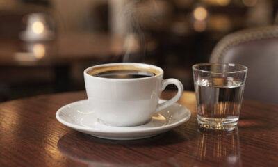 Por que cafeterias servem um copo de água junto com o café