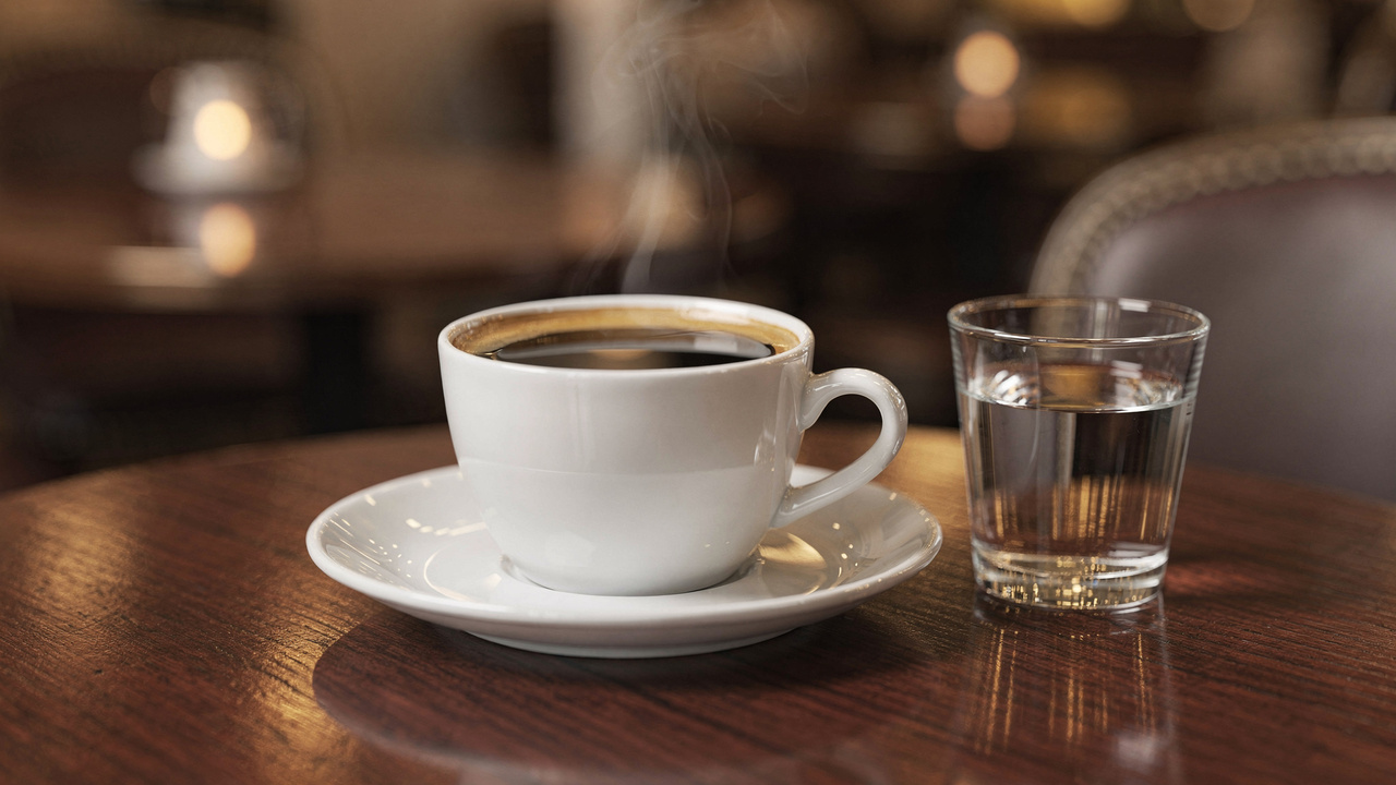 Por que cafeterias servem um copo de água junto com o café