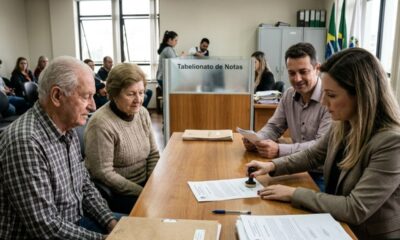 Mulher carimba documento em tabelionato de notas, com casal idoso e homem observando.