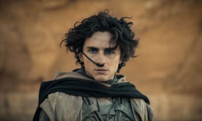 Close-up de Timothée Chalamet como Paul Atreides em Duna, com olhos azuis e traje desértico.