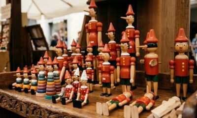 Bonecos de Pinóquio de madeira com narizes longos e chapéus vermelhos em exposição.