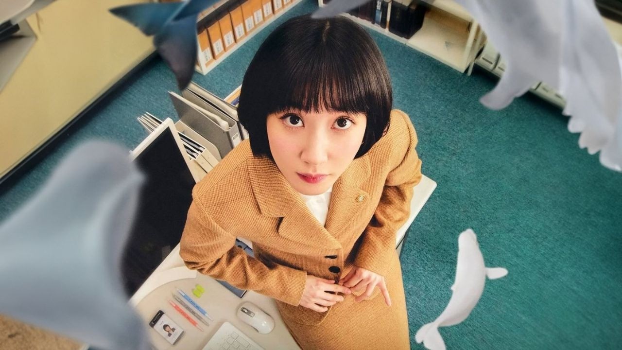 Mulher de blazer bege olhando para cima em escritório, com baleias brancas flutuando ao redor.