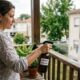 Mulher borrifa "VINAGRE DILUIDO" de um spray em plantas na varanda.